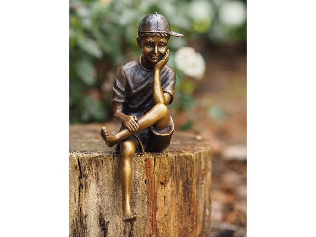 Bronzen beeld Zittende jongen met pet 19x8x6cm